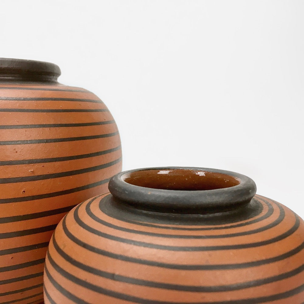 Duo de vases boules Elchinger à rayures noires asymétriques, fond auburn