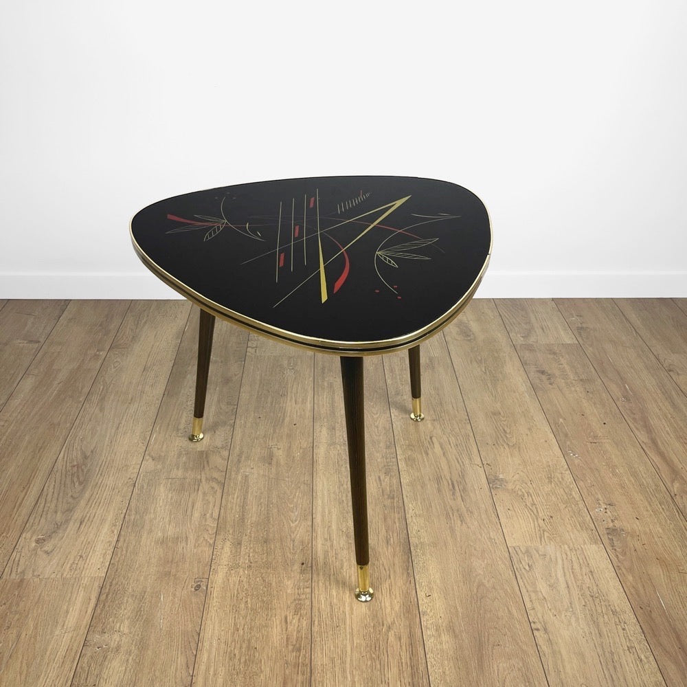 Table basse tripode motifs graphiques noirs et rouges